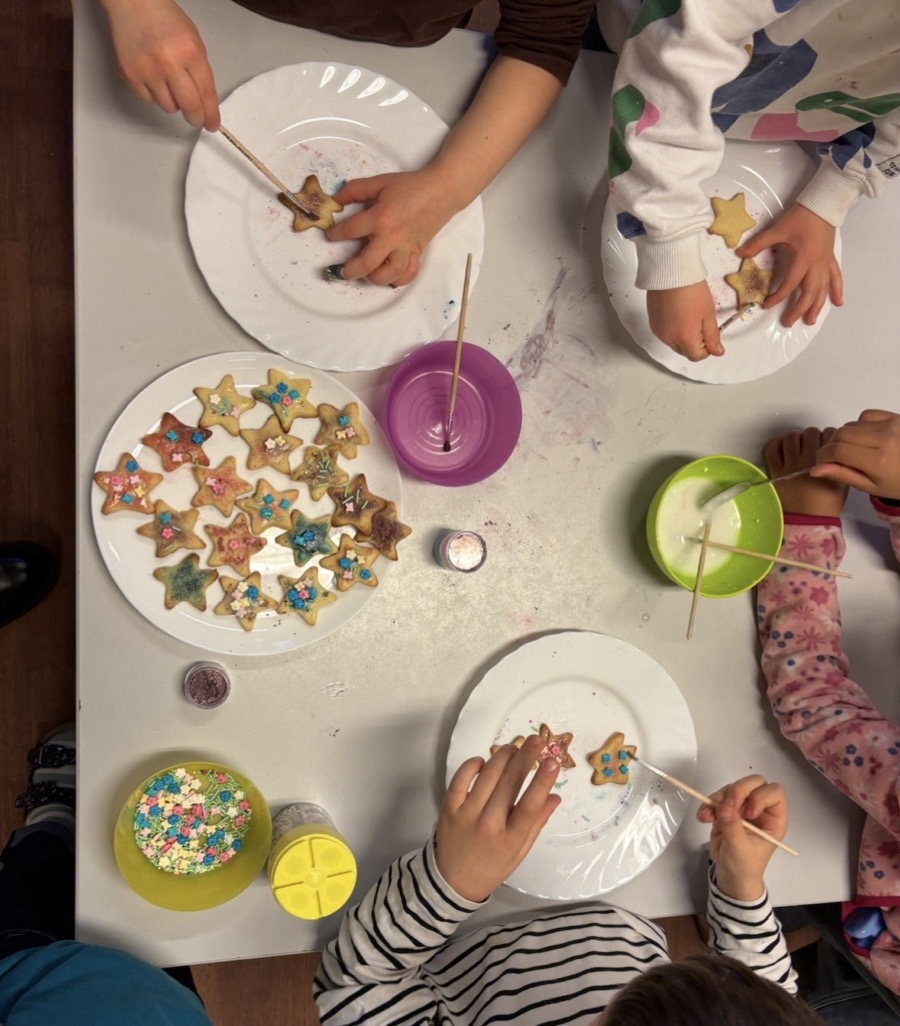 Kinder dekorieren gemeinsam Sternkekse in der erpse